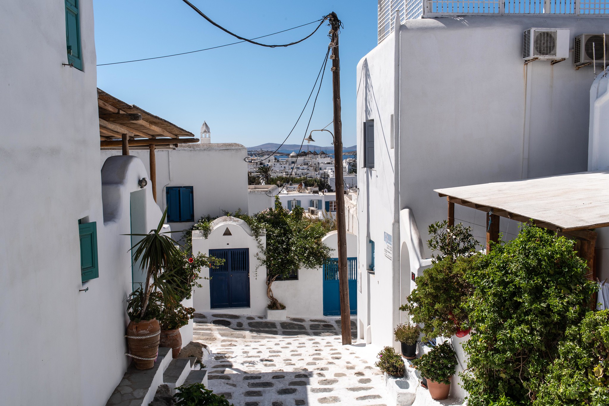 Mykonos alleyway with white houses and plants